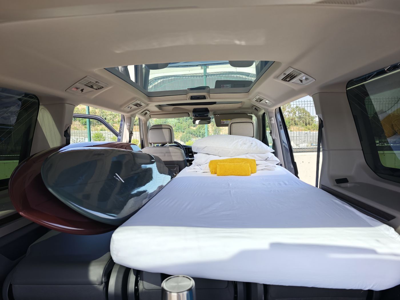 Bed made up for two with surfboards on board